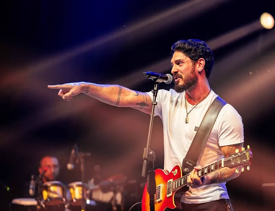 Isaías Neto tocando guitarra e cantando no palco